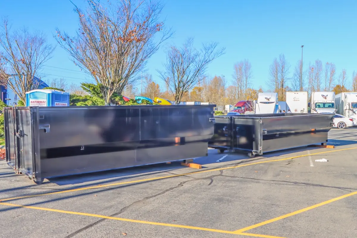 Professional dumpster rental service with roll-off container on residential driveway in West Jefferson